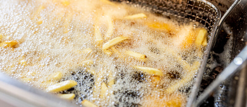 French fries cooking and frying in hot boiling fat in a food truck kitchen. 2026 Blog - Concessionstand fire safety